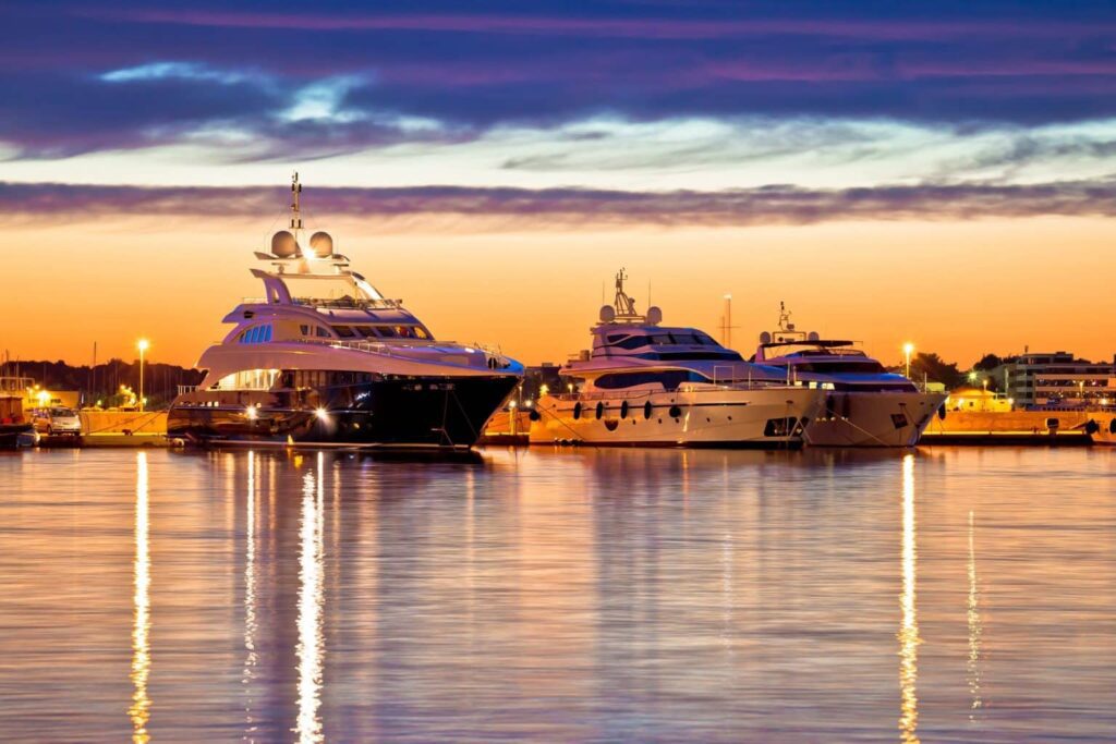 Yachts moored in a marina at sunset